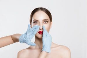 Why People Get Nose Jobs. Woman with marks on face before rhinoplasty cosmetic surgery in clinic.