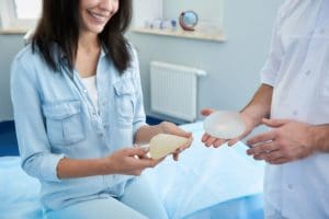 Female patient talking to her plastic surgeon about her breast implant options for breast revision.